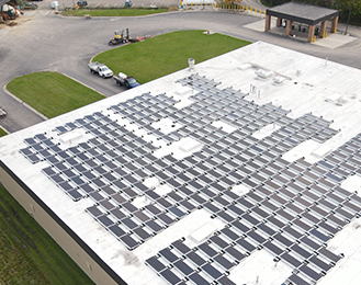 Numerous solar panels on top of the service center building.