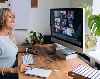 A woman looking at a computer screen with Zoom participants