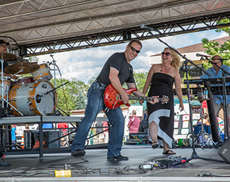 Two people performing live music, one has an electric guitar