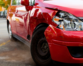 Photo of a car with a broken head light and wheel