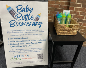 Photo of a basket of baby bottles next to a sign that reads Baby Bottle Boomerang