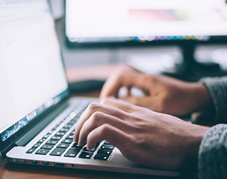 Image of someone typing on a laptop