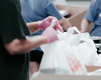 Image of volunteers tying bags of food