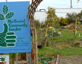 Photo of Northwind Community Garden entrance showing a sign and garden space.