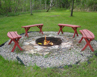 Fire Pit with benches around it outside. 